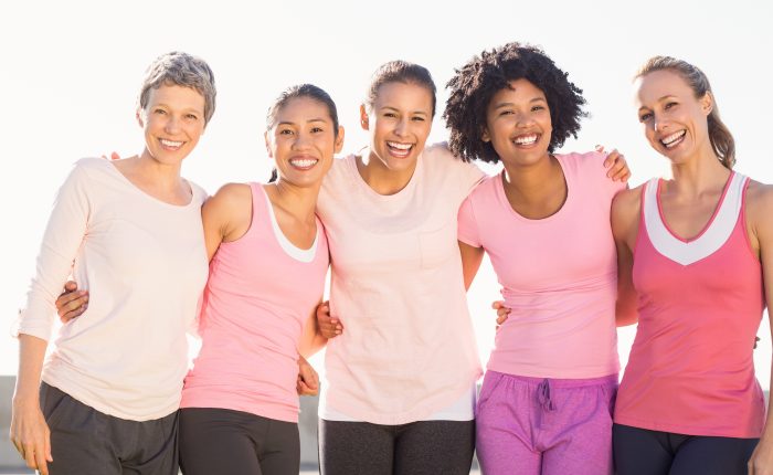 Smiling women wearing pink for breast cancer