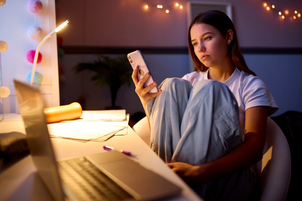 Anxious teen girl on her smartphone